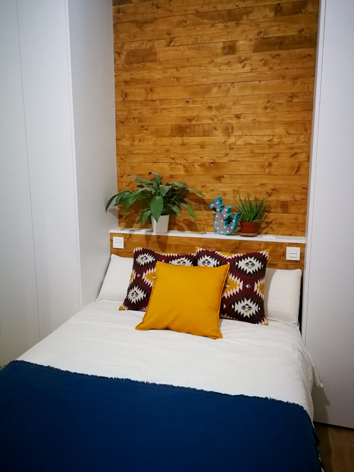 Cabecero de cama revestido en lamas de madera